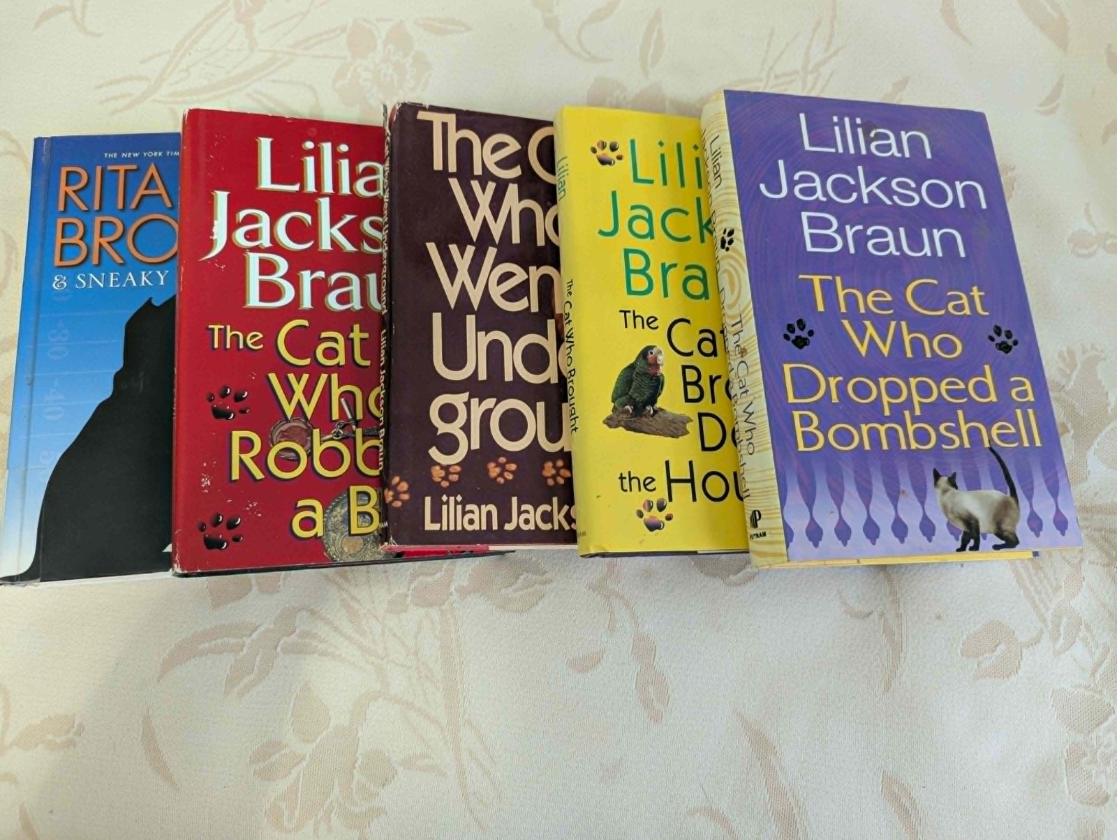 4 “The Cat Who” books by Lilian Jackson Braun, 1 by Rita Mae Brown (“Tail Gait”)