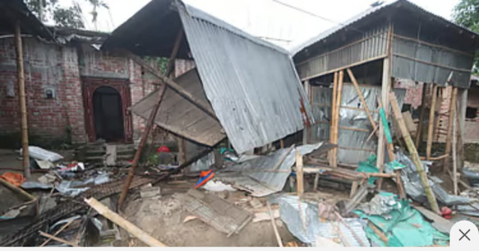 A Hindu family's home in rural Bangladesh stands damaged after a mob attack, with debris and broken religious items visible.