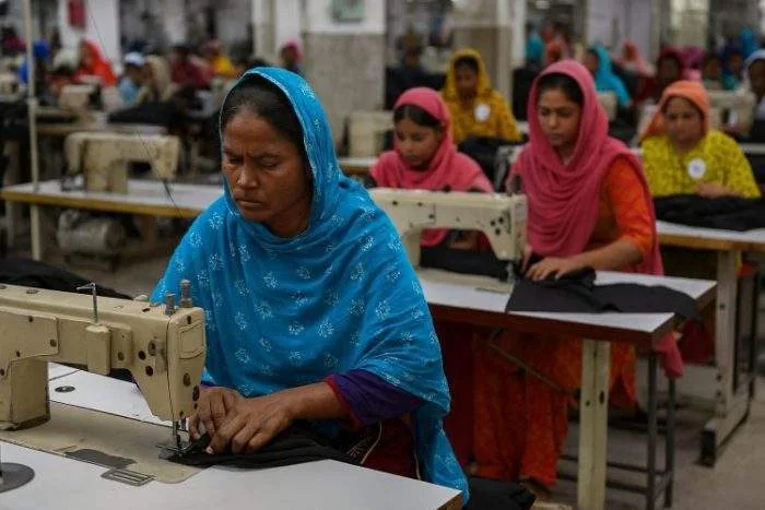 A deserted garment factory floor with scattered sewing machines and dim lighting, symbolizing industrial decline in Bangladesh.