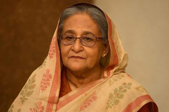 Sheikh Hasina, Bangladesh’s Prime Minister, seated calmly in New Delhi wearing a traditional saree, reflecting during her exile as she calls for a return to constitutional rule.