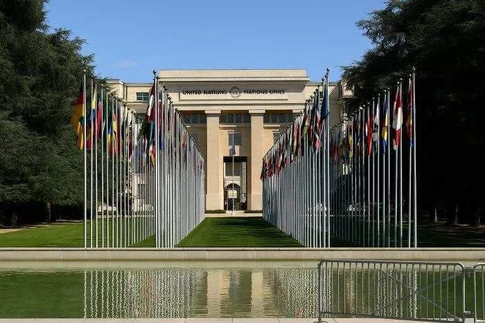 United Nations headquarters in Geneva with rows of national flags lining the approach.