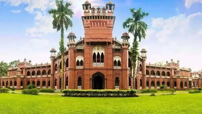 Curzon Hall, a historic red-brick building at the University of Dhaka surrounded by green lawns and palm trees.