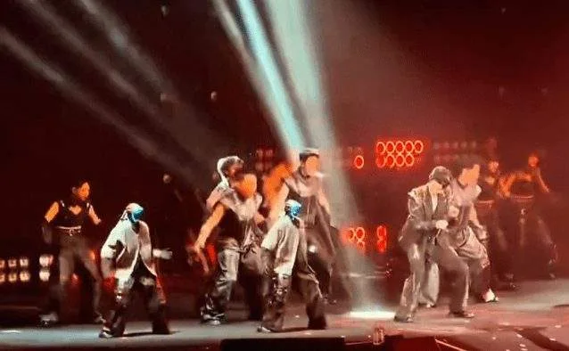 Humanoid robots perform choreographed dance moves on stage alongside human performers at a concert in Chengdu, China.