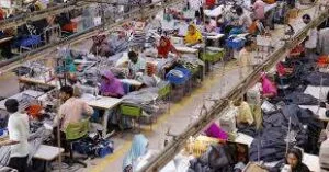 A dimly lit garment factory with idle sewing lines, symbolizing Bangladesh’s stagnant RMG export growth amid global economic slowdown.