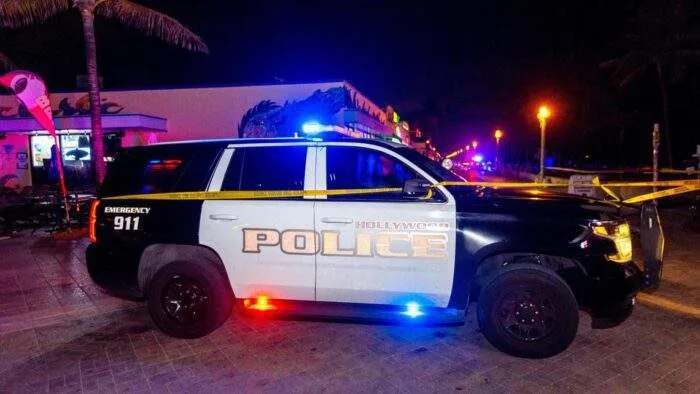 Police presence at a Hollywood intersection at night following an alleged assault involving a ride-share driver.