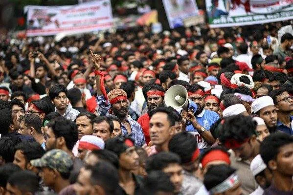 A political discussion event in Dhaka where speakers address allegations surrounding Bangladesh’s interim government.