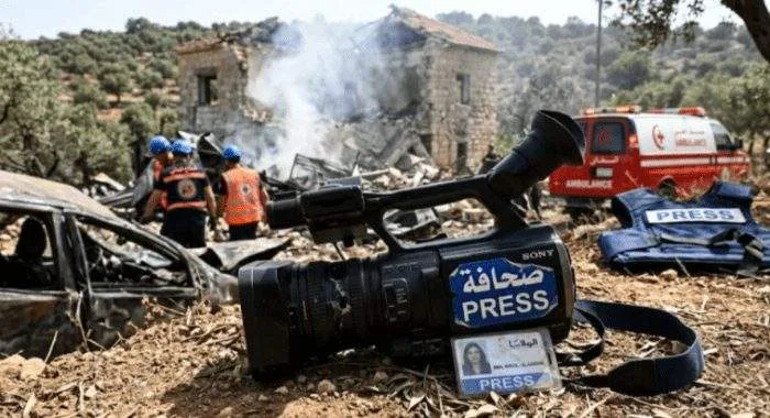 Damaged press gear and a smoldering building in southern Lebanon following an air strike.