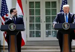 A smartphone showing President Trump’s Truth Social post about the Lebanon ceasefire against the Beirut skyline.