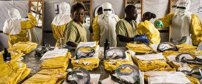 Healthcare workers clad in full protective hazmat gear setting up an isolation unit at a medical facility in eastern DR Congo.