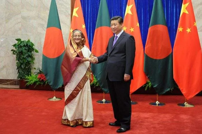 A conceptual graphic showing the Teesta River with the national flags of China, the USA, and Bangladesh, symbolizing diplomatic tension.