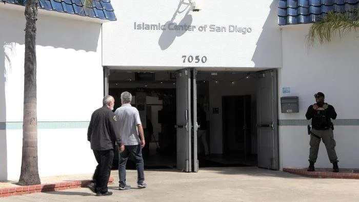 Police tape and emergency vehicles blocking the entrance to the Islamic Center of San Diego in the Clairemont neighborhood as federal agents investigate.