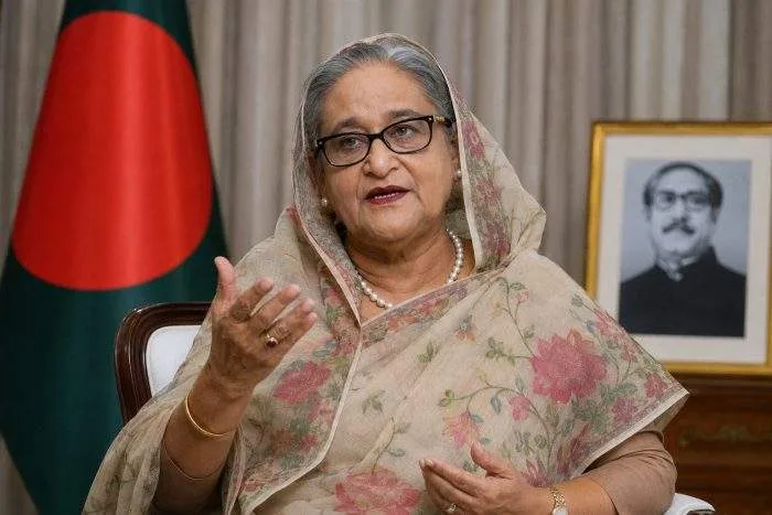 A split-screen editorial graphic showing a recent digital video-call freeze-frame of Sheikh Hasina on the left, and the exterior of the Supreme Court/Tribunal building in Dhaka on the right.