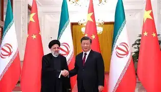 Chinese President Xi Jinping shaking hands with Pakistani Prime Minister Shehbaz Sharif inside the Great Hall of the People in Beijing, flanked by national flags.