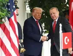 Turkish President Recep Tayyip Erdoğan speaking on the phone in his Ankara office, alongside official state documents and flags.