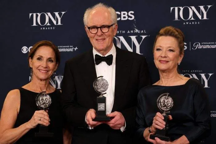 Wide horizontal shot of the 79th Tony Awards stage with the host and winners holding trophies.