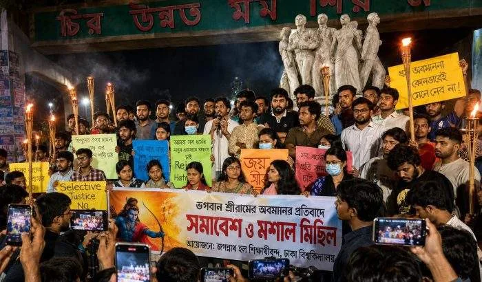 Hindu students and supporters hold a torch-lit protest at the Raju Memorial Sculpture on the University of Dhaka campus, demanding justice over the alleged desecration of an image of Lord Ram and calling for the protection of religious rights.