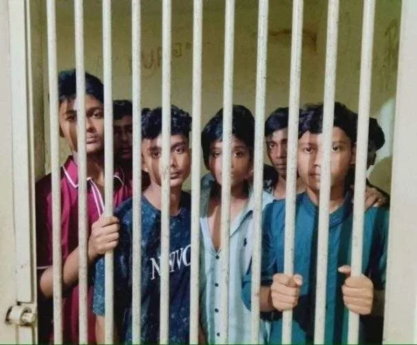 A group of concerned guardians and local citizens gathered outside a regional government office in Noakhali, discussing intensely under an overcast sky.