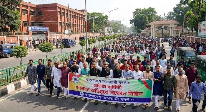 Horizontal view of a political procession marching past Mirpur Road toward the main gate of Ganabhaban in Dhaka.