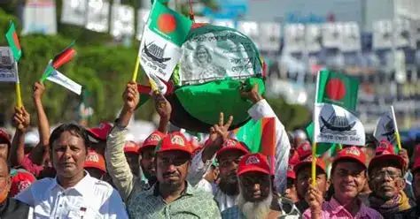 Political activists participate in a street procession in Dhaka while police maintain a security presence nearby.