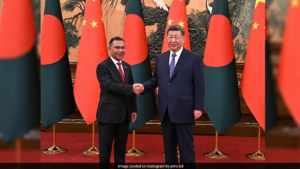 Horizontal shot of Bangladeshi and Chinese officials exchanging signed bilateral documents during a ceremony in Beijing.