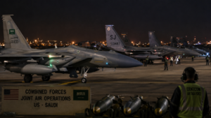 Horizontal shot showing military fighter jets on a runway preparing for night operations in the Middle East.