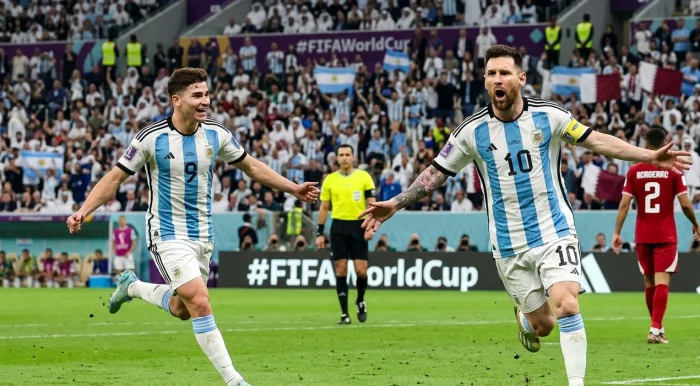Lionel Messi sprinting and shouting in celebration with open arms alongside teammate Julián Álvarez after scoring a goal for Argentina at the FIFA World Cup stadium.