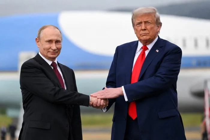 A wide-angle, horizontal split graphic showcasing symbolic diplomatic imagery with the Kremlin palace silhouette on one side and the White House facade on the other, linked by an abstract digital data globe indicating high-level strategic communication.
