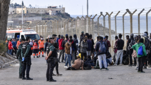 Migrants gathering along the Ceuta border fence amidst the EU migration crisis